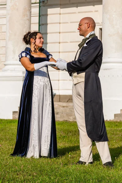 Şatonun arka planında eski moda elbiseli bir adamla güzel bir kız. Yakın plan.