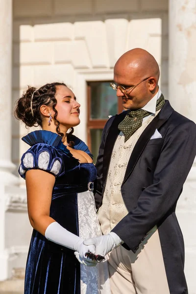 Şatonun arka planında eski moda elbiseli bir adamla güzel bir kız. Yakın plan.