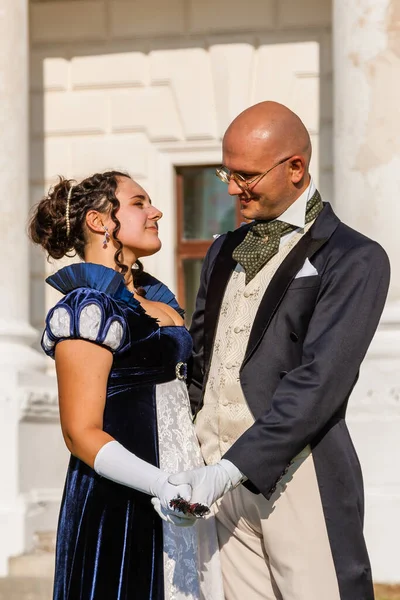 Şatonun arka planında eski moda elbiseli bir adamla güzel bir kız. Yakın plan.