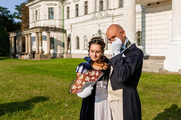 Şatonun arka planında eski moda elbiseli bir adamla güzel bir kız. Yakın plan.