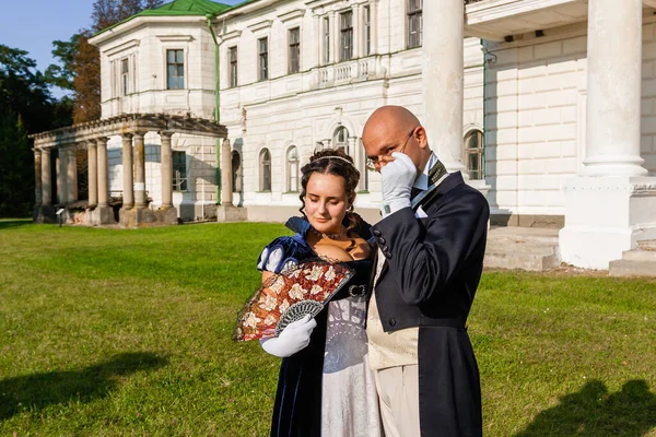 Şatonun arka planında eski moda elbiseli bir adamla güzel bir kız. Yakın plan.