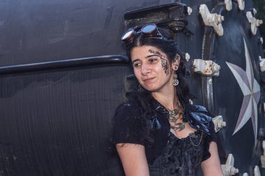 Steampunk elbiseli güzel bir kız trenin arka planında. Yaklaş.