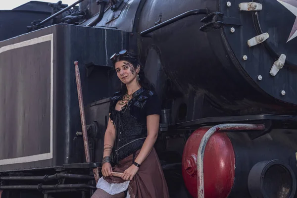 Beautiful girl in steampunk clothes on the background of the train close up