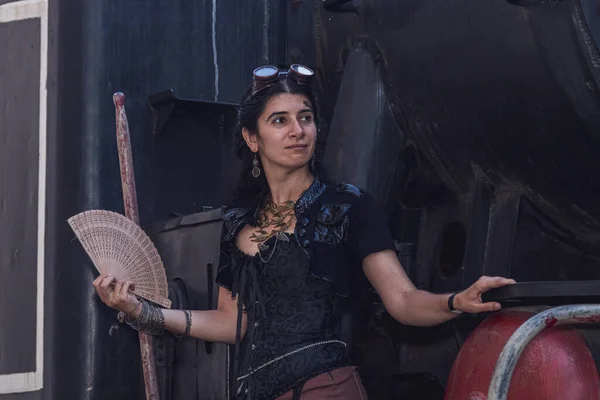 Beautiful girl in steampunk clothes on the background of the train close up