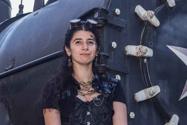 Beautiful girl in steampunk clothes on the background of the train close up