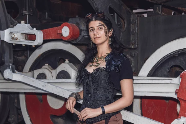 Beautiful girl in steampunk clothes on the background of the train close up