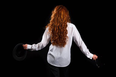 Beyaz gömlekli, siyah arka planda şapkası olan güzel bir kız.