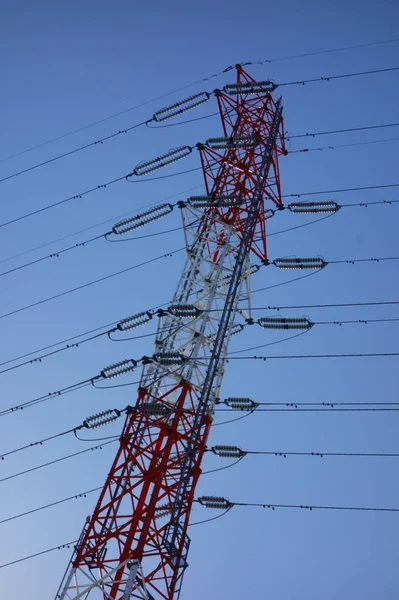 A fancy transmission line tower that shines in the blue sky