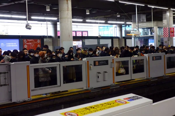 通勤客で賑わう早朝駅のホームセキュリティドア — ストック写真