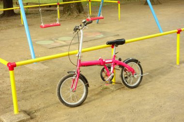 Çocuk parkında geçen şık ve sevimli bir çocuk bisikleti.