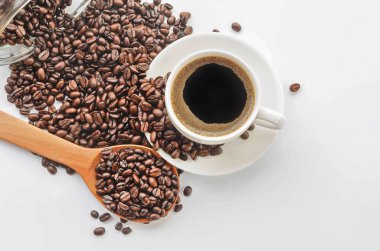 Kahve fincanı ve tabağı, beyaz bir arka plan üzerinde kahve çekirdekleri.