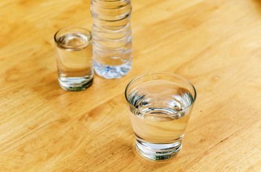 Bir cam şişe masanın üzerinde su içme.