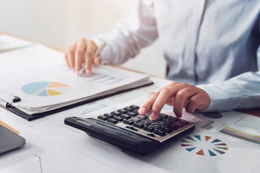 Finans ve muhasebe alanında çalışan iş kadını, ofisteki mali bütçeyi analiz ediyor 