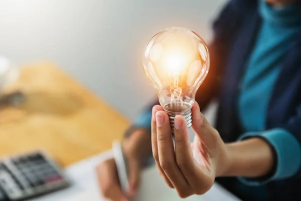Концепция экономии энергии. business woman holding light bulb in o — стоковое фото