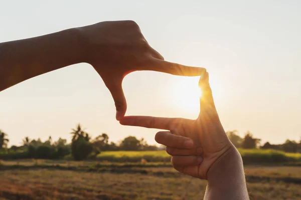 Nahaufnahme Handrahmung Blick weit über den Sonnenuntergang. Geschäftskonzept — Stockfoto