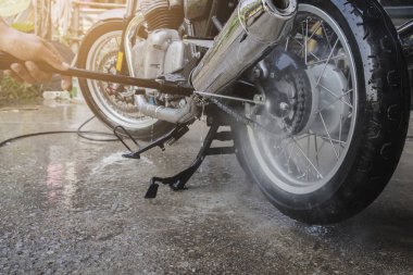 İnsanlar evde motosiklet yıkarlar.