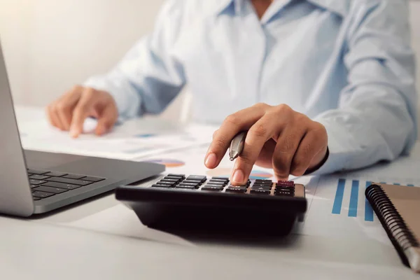 Бизнесвумен, работающая за столом с помощью калькулятора анализа финансов — стоковое фото