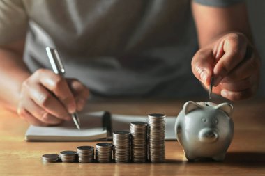 saving money with hand putting coins in piggy bank concept finan