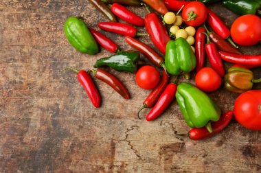 Masa arkasında domates olan kırmızı biber.