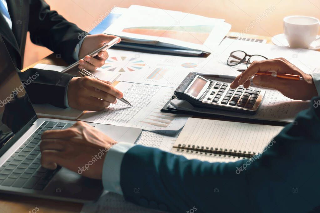 businessman use calculator and computer for  meeting with team accountant on desk in office. finance and accounting concept
