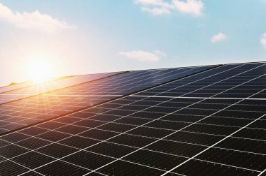 Mavi gökyüzü ve günbatımına sahip güneş pili paneli. Doğadaki enerji temizliği kavramı