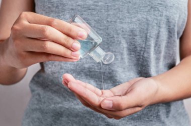 Kadın, Coronavirus Covid 19 'u temizlemek için şişeye alkol jeli pompalıyor. 