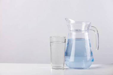 Beyaz arka plan üzerinde izole su ile cam sürahi