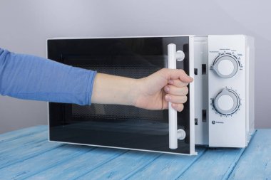 Yeni beyaz mikrodalga fırın, mavi ahşap yüzeye Isıtma için