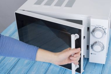 Yeni beyaz mikrodalga fırın, mavi ahşap yüzeye Isıtma için