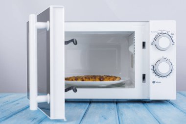 Yeni beyaz mikrodalga fırın, mavi ahşap yüzeye Isıtma için