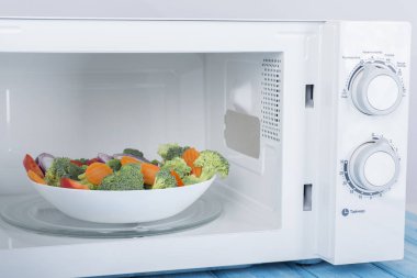 Yeni beyaz mikrodalga fırın, mavi ahşap yüzeye Isıtma için