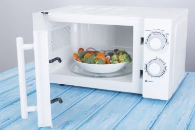 Yeni beyaz mikrodalga fırın, mavi ahşap yüzeye Isıtma için