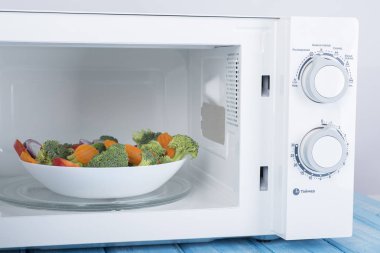 Yeni beyaz mikrodalga fırın, mavi ahşap yüzeye Isıtma için