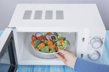 Yeni beyaz mikrodalga fırın, mavi ahşap yüzeye Isıtma için