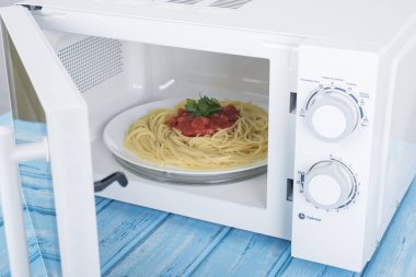 Yeni beyaz mikrodalga fırın, mavi ahşap yüzeye Isıtma için