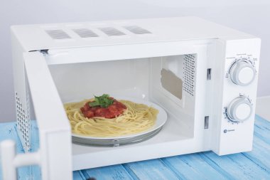 Yeni beyaz mikrodalga fırın, mavi ahşap yüzeye Isıtma için