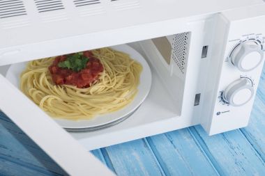 Yeni beyaz mikrodalga fırın, mavi ahşap yüzeye Isıtma için