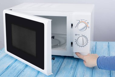 Yeni beyaz mikrodalga fırın, mavi ahşap yüzeye Isıtma için