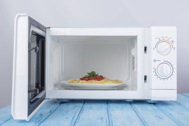 Yeni beyaz mikrodalga fırın, mavi ahşap yüzeye Isıtma için