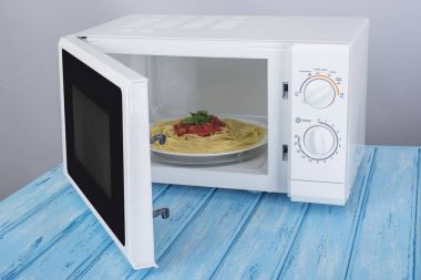 Yeni beyaz mikrodalga fırın, mavi ahşap yüzeye Isıtma için