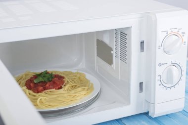 Yeni beyaz mikrodalga fırın, mavi ahşap yüzeye Isıtma için