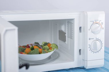 Yeni beyaz mikrodalga fırın, mavi ahşap yüzeye Isıtma için