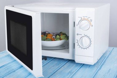 Yeni beyaz mikrodalga fırın, mavi ahşap yüzeye Isıtma için