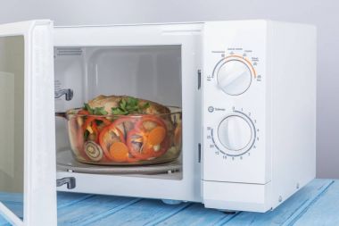 Yeni beyaz mikrodalga fırın, mavi ahşap yüzeye Isıtma için