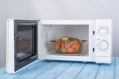 Yeni beyaz mikrodalga fırın, mavi ahşap yüzeye Isıtma için