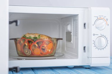 Yeni beyaz mikrodalga fırın, mavi ahşap yüzeye Isıtma için