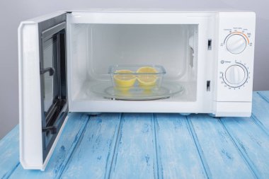 Yeni beyaz mikrodalga fırın, mavi ahşap yüzeye Isıtma için