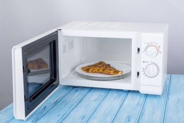 Yeni beyaz mikrodalga fırın, mavi ahşap yüzeye Isıtma için