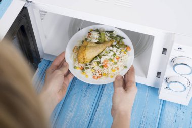 Gıda Isıtma için mavi bir ahşap yüzey üzerinde beyaz mikrodalga fırın