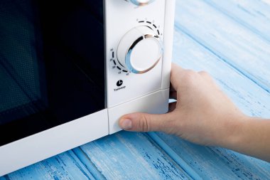 Gıda Isıtma için mavi bir ahşap yüzey üzerinde beyaz mikrodalga fırın